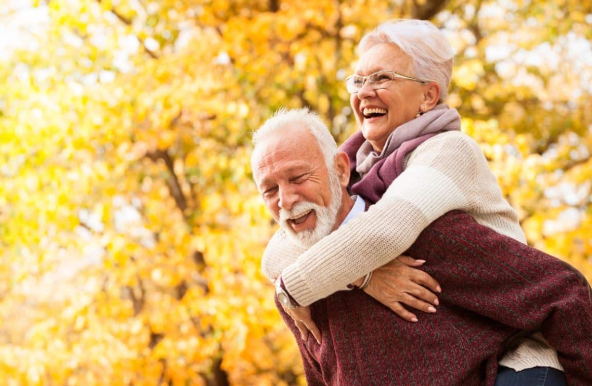 Couple senior célébrant 53 ans de mariage lors des noces de merisier, symbole d’un amour durable et enraciné, dans une ambiance chaleureuse et automnale.